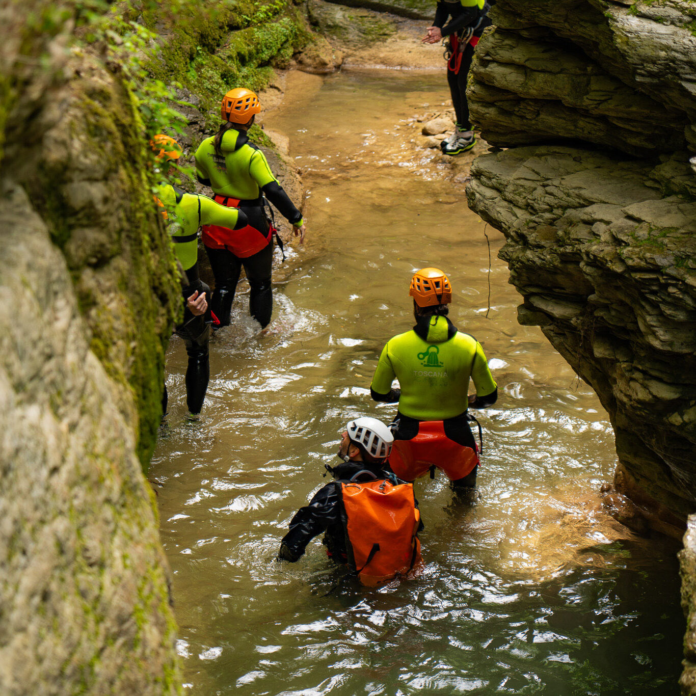 Partecipanti che attraversano un tratto stretto e suggestivo del Rio Buti a Vaiano, Prato, durante un’attività di canyoning in Toscana. Le pareti rocciose ravvicinate e l’acqua che scorre creano un ambiente naturale spettacolare, ideale per escursioni canyoning in Val di Bisenzio.